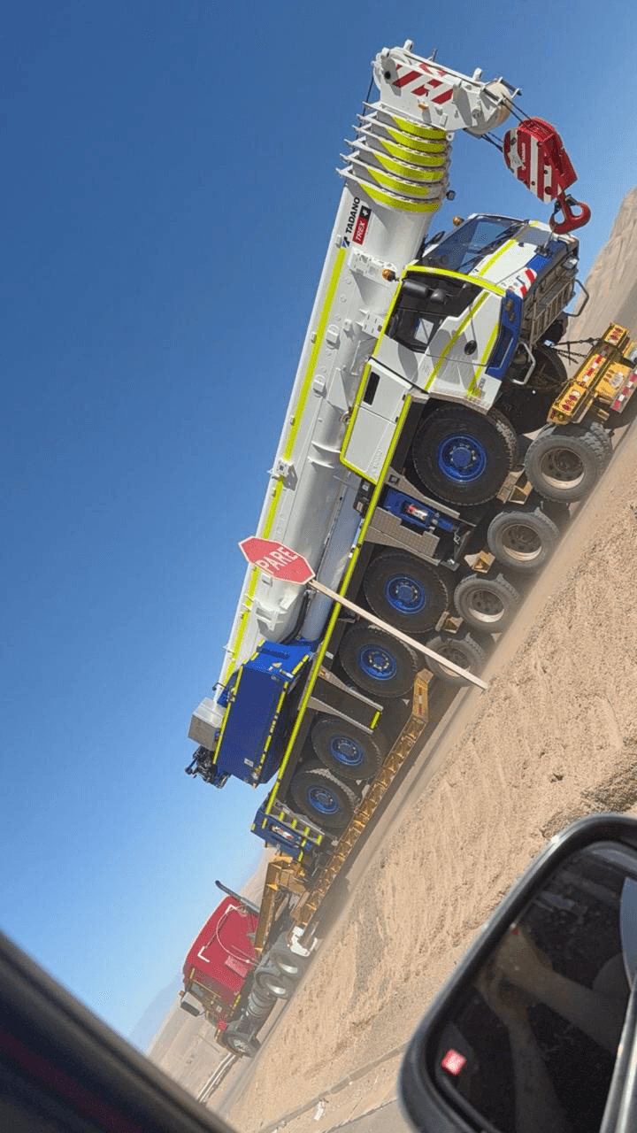 Camión Mack rojo cargando equipo de construcción
